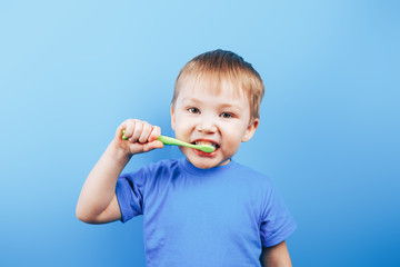 Small boy holding toothbrush and show his perfect teeth.