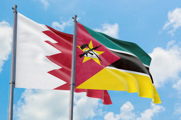 Fototapeta na wymiar Mozambique and Bahrain flags waving in the wind against white cloudy blue sky together. Diplomacy concept, international relations.