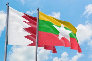 Myanmar and Bahrain flags waving in the wind against white cloudy blue sky together. Diplomacy concept, international relations.