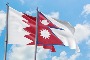 Nepal and Bahrain flags waving in the wind against white cloudy blue sky together. Diplomacy concept, international relations.