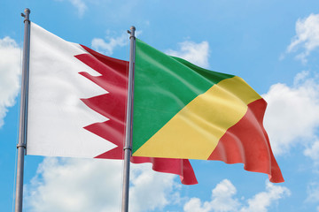 Republic Of The Congo and Bahrain flags waving in the wind against white cloudy blue sky together. Diplomacy concept, international relations.