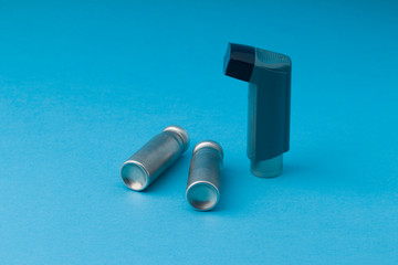Asthma inhaler on blue background. copy space