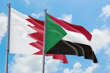Sudan and Bahrain flags waving in the wind against white cloudy blue sky together. Diplomacy concept, international relations.