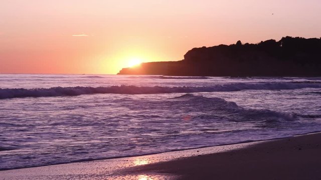 Atlantic Ocean sunset view in Armacao de Pera in the Algarve in Portugal. Light of my life. Beautiful golden sun rays. Real time 4K video. Waves crashing at the beach. Ideas are water.
