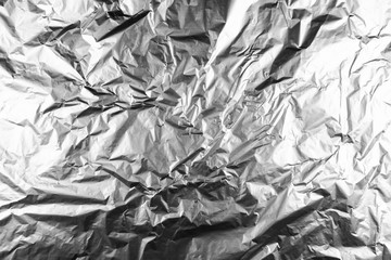 Close up of aluminium foil crumpled. Silver aluminium foil texture background. Abstract metallic paper pattern. Texture of crumpled aluminum kitchen foil. Silver abstract background