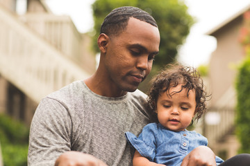 Fototapeta premium Father holding his little girl. Mixed race family.