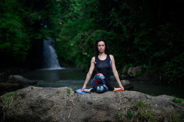Fototapeta premium Yoga practice and meditation in nature. Woman practicing near river