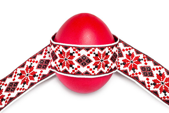 Red egg with national traditional ribbon on a white background