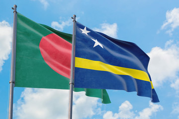 Curacao and Bangladesh flags waving in the wind against white cloudy blue sky together. Diplomacy concept, international relations.