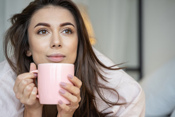Dreamy girl holding a mug of coffee