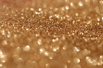 Golden shine background. Gold glitter with golden shiny bokeh. Glitter macro shimmer  texture.Vibrant background with twinkle lights. glitter brilliant mockup
