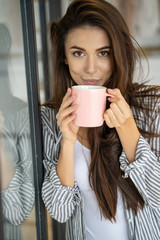 Lovely young woman drinking a hot beverage