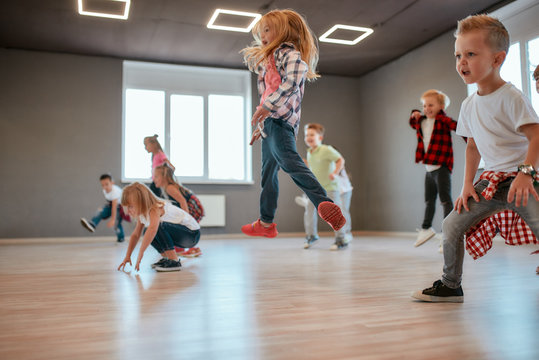 Getting higher. Children jumping while having a choreography class. Group of cute little boys and girls studying modern dance in studio