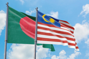 Malaysia and Bangladesh flags waving in the wind against white cloudy blue sky together. Diplomacy concept, international relations.