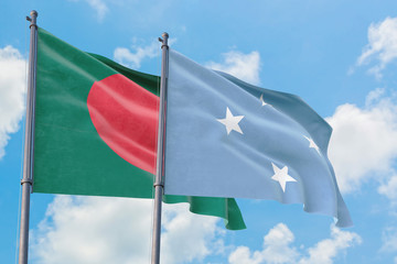 Micronesia and Bangladesh flags waving in the wind against white cloudy blue sky together. Diplomacy concept, international relations.