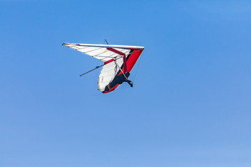 Hang-glider flying through the clear blue. Hang-gliding competition in Creston, British Columbia, Canada. Overhead view.