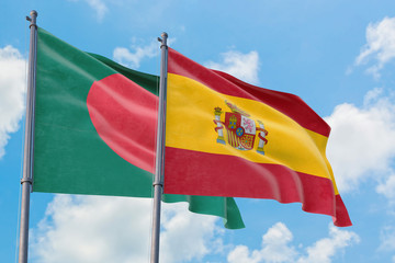 Spain and Bangladesh flags waving in the wind against white cloudy blue sky together. Diplomacy concept, international relations.