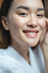Beautiful Asian woman wearing white bathrobe in beauty salon