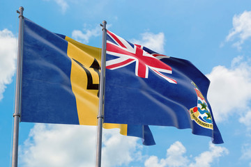 Cayman Islands and Barbados flags waving in the wind against white cloudy blue sky together. Diplomacy concept, international relations.