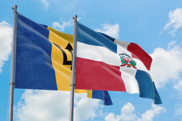 Dominican Republic and Barbados flags waving in the wind against white cloudy blue sky together. Diplomacy concept, international relations.
