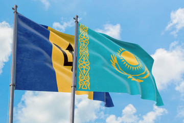 Kazakhstan and Barbados flags waving in the wind against white cloudy blue sky together. Diplomacy concept, international relations.