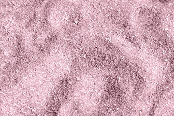 Beach sand texture close-up. Natural background pink color toned