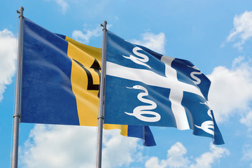 Martinique and Barbados flags waving in the wind against white cloudy blue sky together. Diplomacy concept, international relations.