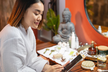 Asian pretty lady using her tablet near mirror