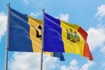 Moldova and Barbados flags waving in the wind against white cloudy blue sky together. Diplomacy concept, international relations.