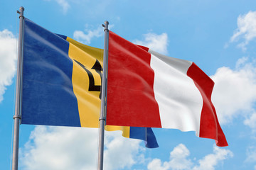 Peru and Barbados flags waving in the wind against white cloudy blue sky together. Diplomacy concept, international relations.