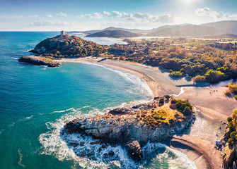View from flying drone. Astonishing spring view of popular tourist destination - Acropoli di Bithia with Torre di Chia tower on background. Aerial morning view of Sardinia island, Italy, Europe. - obrazy, fototapety, plakaty