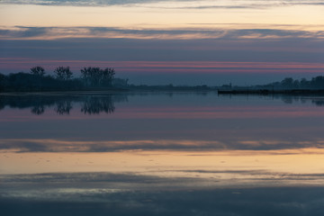 Landscape evening with sunset on a lake with lilies, with beautiful sky in summer season	