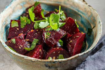 Baked beetroot salad with cilantro in bowl. Healthy vegan food concept.