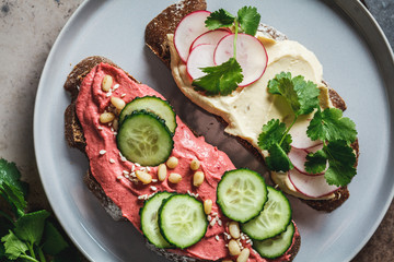 Beetroot and classic hummus toasts, top view. Vegan food concept.