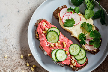 Beetroot and classic hummus toasts, top view. Vegan food concept.