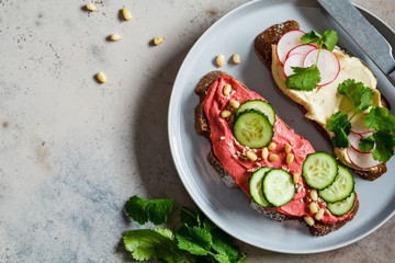 Beetroot and classic hummus toasts, top view. Vegan food concept.