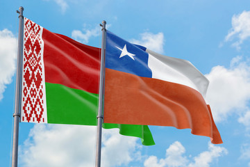 Chile and Belarus flags waving in the wind against white cloudy blue sky together. Diplomacy concept, international relations.