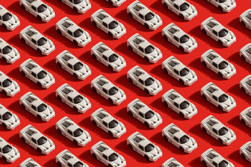 pattern of white toy car model Ferrari on red background