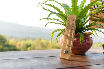 Outdoor wood thermometer calibrated in celsius and fahrenheit scale showing 15 degrees celsius or...