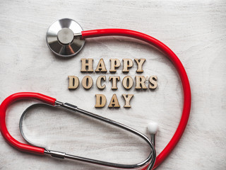HAPPY DOCTOR'S DAY. Beautiful card. Isolated background, wooden surface. Congratulations for relatives, friends and colleagues