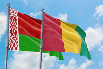Guinea and Belarus flags waving in the wind against white cloudy blue sky together. Diplomacy concept, international relations.