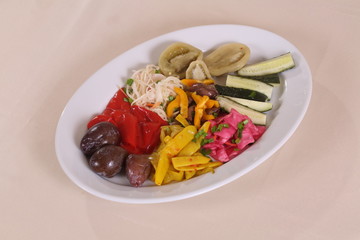 Plate with marinades: cucumbers, tomatoes, cabbage, peppers, plums