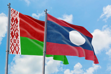 Laos and Belarus flags waving in the wind against white cloudy blue sky together. Diplomacy concept, international relations.