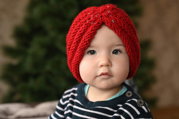 Red hat and baby. one year old child portrait. close-up.