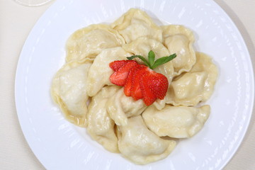 Dumplings with strawberries on a white plate
