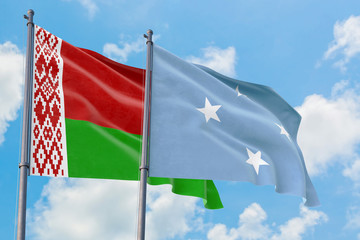 Micronesia and Belarus flags waving in the wind against white cloudy blue sky together. Diplomacy concept, international relations.