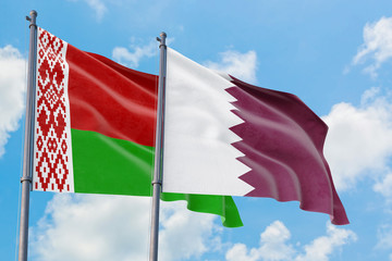 Qatar and Belarus flags waving in the wind against white cloudy blue sky together. Diplomacy concept, international relations.
