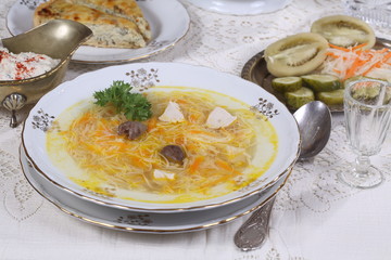 chicken soup with vermicelli, a glass of vodka and pickles