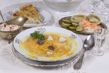 chicken soup with vermicelli, a glass of vodka and pickles