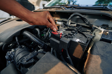 Fototapeta na wymiar Close-up image of woman checking or changing car battery